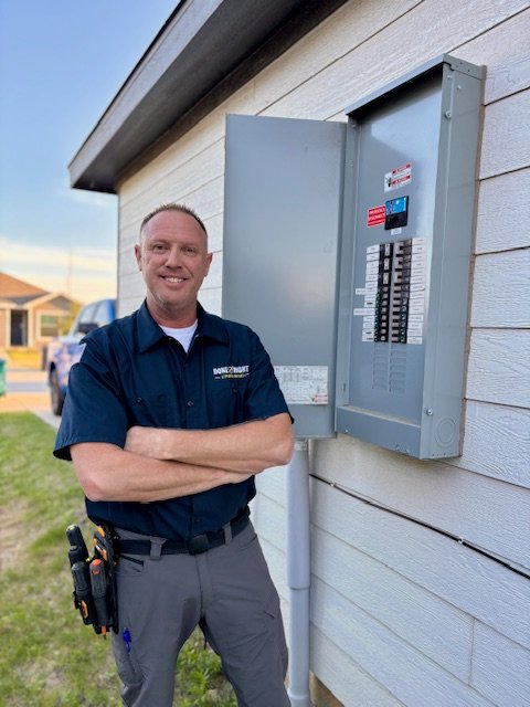 Scott inspecting a home electrical panel while explaining findings
